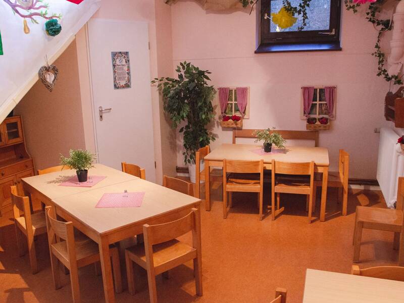 Innenraum des Kindergartens Sankt Georg in Bad Aibling mit Tischen und Stühlen.